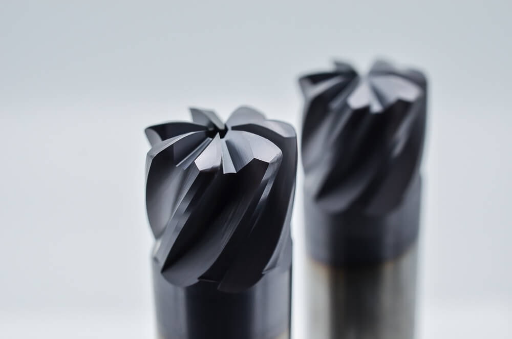 Carbide end mills for titanium cutting paired with CNC coolant flood system, illustrating specialized tools and cooling setup for efficient titanium machining