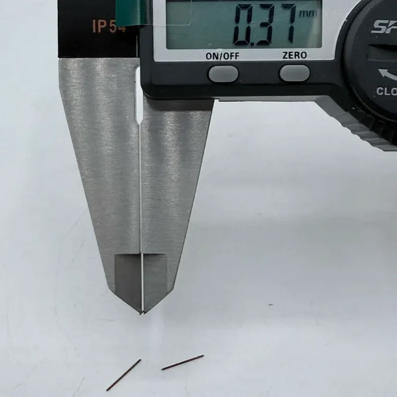 High - precision CNC machined micro pins measured by digital calipers, showing 0.37mm diameter, ideal for electronics assembly.