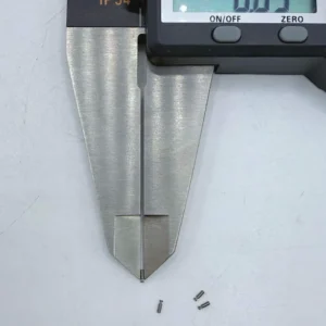 Micro stainless steel pins, CNC machined, being measured by a digital caliper, suitable for high - precision electronics assembly.