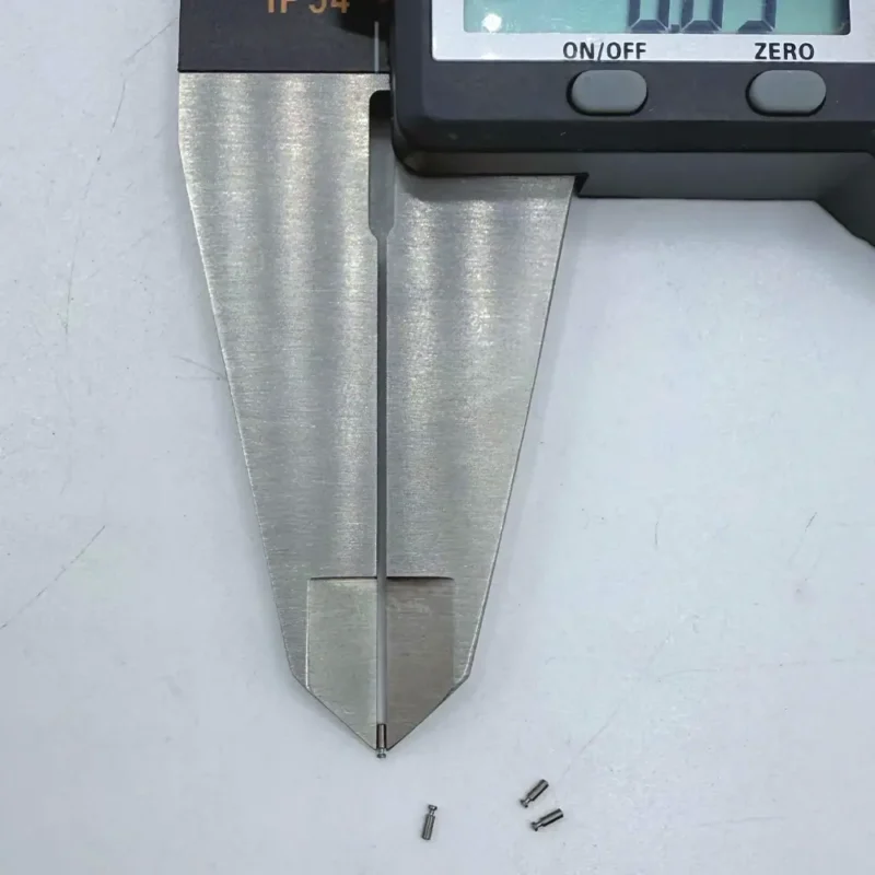 Micro stainless steel pins, CNC machined, being measured by a digital caliper, suitable for high - precision electronics assembly.