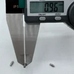 Digital caliper displaying 0.96mm measurement of precision shaft