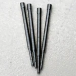 Group of four stainless steel precision micro pins on a light surface