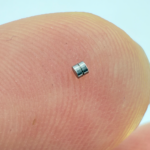 Stainless steel micro precision turned pin placed on fingertip