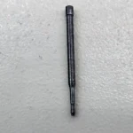 Micro precision pin held in metal vise for machining or inspection