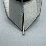 Stainless steel precision pin held in vise for machining