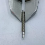 Stainless steel precision worm gear shaft held in metal vise for machining